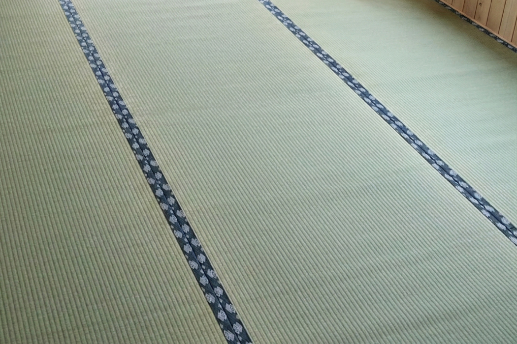 Emi Japandi tatami mat, slate-blue geometric diamond border on a bedroom floor